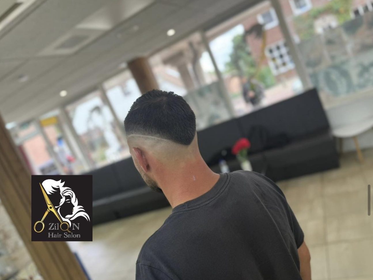 Herenkapsel met een skin fade, van achteren in de salon
